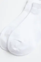 Pack de tres pares de medias deportivas blancas de corte bajo, confeccionadas en tejido DryMove™ con secciones caladas para mayor ventilación.