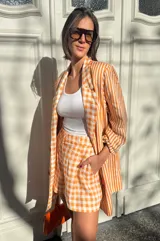 Short de lino a cuadros color naranja y blanco, estilo sastrero con calce holgado.