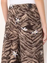 Pantalón wide leg de tiro alto con estampado de cebra y flores blancas.