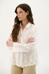 Camisa blanca con bordado floral, de corte holgado y manga larga.