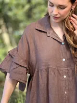 Vestido camisero azul de lino italiano, con cuello camisero, botones frontales, mangas 3/4 con doble volado y bolsillos laterales.