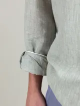 Camisa blanca de lino con corte regular fit, cuello italiano, cierre con botones, manga larga y logo bordado en el pecho.