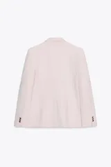 Blazer color rosa pálido de corte entallado y doble botonadura dorada.