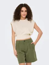 Top tejido color crema sin mangas con cuello redondo y corte regular.