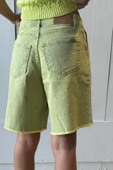 Bermuda de jean color marrón con tiro medio-alto, detalle de pinzas y terminación desflecada.