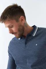 Polo de manga larga a rayas azul marino y blancas, con cuello clásico y logo bordado en el pecho. Corte regular.