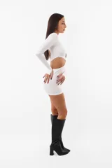 Vestido corto blanco de microfibra, ajustado al cuerpo, con aberturas en el frente y en los laterales. Tiene mangas largas con mitones en los pulgares y elástico interno en las terminaciones.
