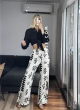 Pantalón palazzo blanco con estampado de motivos tribales en negro, cintura elástica y bolsillos laterales. Talle único.
