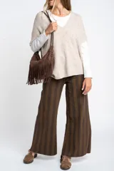 Chaleco de punto oversize con escote en V, hombros caídos y textura acanalada en color beige, confeccionado en una mezcla de acrílico, poliéster, nylon, lana y spandex.