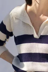 Sweater tejido artesanalmente en hilado 70% algodón y 30% acrílico, con cuello polo y rayas horizontales anchas color azul marino sobre fondo crudo.