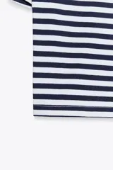 Camiseta corta a rayas horizontales blancas y azul marino, de algodón, con cuello redondo y mangas cortas.