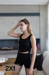 Conjunto deportivo negro de algodón y lycra, compuesto por un top musculosa con sisas amplias y un short ajustado con cordón lateral.
