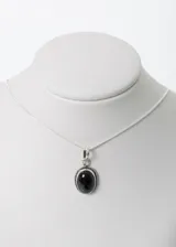 Collar con cadena de plata y dije ovalado con piedra de ónix negra.