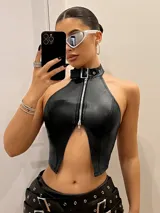 Top negro de cuero sintético con cuello halter, cierre frontal con cremallera y abertura en el abdomen.