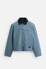 Cazadora relaxed fit de algodón acolchado, color celeste con efecto lavado. Tiene cuello solapa, manga larga con puño abotonado, bolsillos con cremallera en pecho y cadera, y cierre frontal con cremallera.