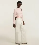 Blusa de chenille color rosa claro, con cuello alto y mangas largas.