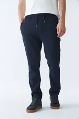 Pantalón deportivo color azul marino con fit regular, detalle de logo en goma, cintura elástica con cordón y tres bolsillos.