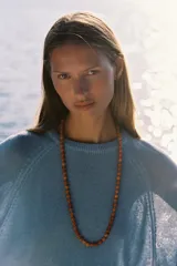 Suéter celeste de punto con cuello redondo y mangas 3/4 acampanadas.