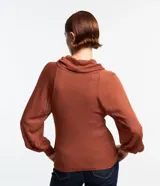 Blusa de punto color ladrillo con cuello alto boba, mangas largas con puños ajustados y detalle de hilo metalizado.