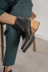 Bota corta de cuero color marrón con cierre lateral, punta fina y taco de madera.
