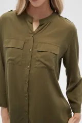 Camisa de viscosa con estampado floral en tonos azul, beige y blanco. Tiene cuello mao, mangas largas y bolsillos en el pecho.