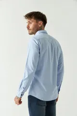 Camisa celeste de manga larga para hombre, con logo bordado y fit slim. Confeccionada en 100% algodón.
