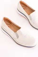Slip-on deportivos color plateado con textura tipo piel de cocodrilo y suela de plataforma con detalle de línea negra.