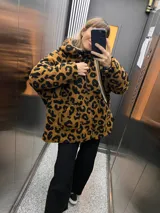 Campera con capucha de tela tipo peluche color marrón con estampado animal print de leopardo en negro.
