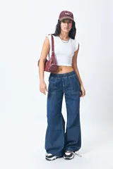 Pantalón de jean ancho con elástico en la cintura y cordones ajustables en los bajos. Cuenta con grandes bolsillos laterales y traseros.
