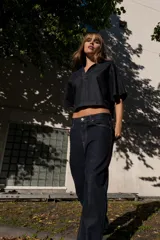 Pantalón de jean azul oscuro, de tiro alto, corte amplio y largo regular.