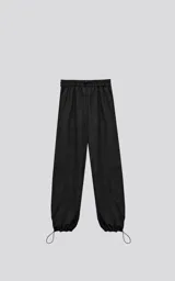 Pantalón negro de corte sastrero holgado, con dos bolsillos laterales, cintura elástica ajustable con tanca y cierre con botón y cremallera.