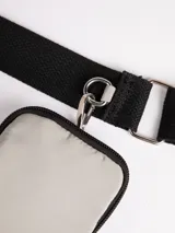 Cartera tipo bandolera de nylon color gris, con correa desmontable y regulable, y monedero a tono.
