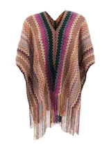 Poncho de tejido de punto con cuello en V y diseño de zigzag multicolor, con flecos largos en el ruedo.