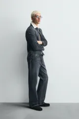 Pantalón de jean de tiro medio, color gris oscuro con efecto lavado, corte ajustado en la parte superior y acampanado desde la rodilla, con cinco bolsillos y cierre frontal con cremallera y botón.
