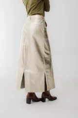 Falda larga de cuero sintético color champagne, corte recto con abertura frontal.