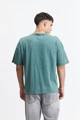 Remera azul de manga corta con cuello redondo, corte holgado y logo bordado en el pecho.