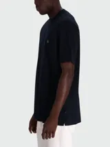 Remera de manga corta, cuello redondo y calce regular, color azul marino oscuro, con un pequeño logo bordado en el pecho.