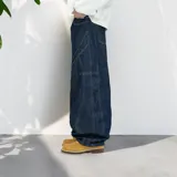 Pantalón jean azul oscuro, corte ultra baggy, tiro alto y diseño con costuras a la vista.
