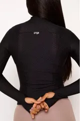 Campera negra de poliamida y elastano con textura tipo panal, cierre frontal completo, cuello alto y mangas largas con orificios para los pulgares.