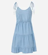 Vestido corto de jeans celeste, con breteles finos con lazos, escote en U, espalda descubierta y falda de tres niveles con volados.