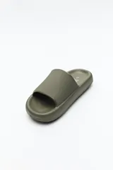 Sandalia chata color verde militar, con capellada ancha y suela plana.