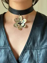 Choker de simil cuero, con diseño de doble flor texturada y canutillos en el centro.