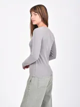 Remera de manga larga confeccionada en tejido de punto acanalado, con cuello redondo y calce ajustado al cuerpo.