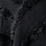Poncho negro con flecos y detalles de textura en diagonal.