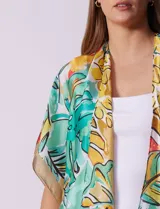 Kimono largo de satén estampado con motivos florales y hojas en tonos verde, amarillo, beige y celeste.