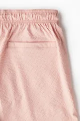 Short de baño color rosa con textura de sirsaca, elástico y cordón ajustable en la cintura, bolsillos laterales, bolsillo trasero ribeteado, aberturas laterales cortas y suspensor interior de malla.