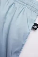 Short de baño con degradé de celeste a azul marino, con cintura elástica ajustable, dos bolsillos laterales y uno trasero con cierre. Cuenta con suspensor de malla fina hipoalergénico y protección UV 50.