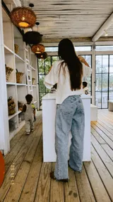 Blusa de color natural confeccionada en tejido 100% algodón. Presenta un cuerpo delantero fruncido tipo smock, vuelo peplum en la cintura y mangas globo 3/4 con volados en los puños.