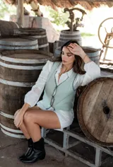 Chaleco tejido color verde agua con terminaciones en negro.