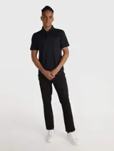 Pantalón de corte slim color negro, confeccionado en algodón y elastano, con diseño de cinco bolsillos, cierre con botón y cremallera, detalles distintivos de Calvin Klein y logo en el bolsillo trasero.